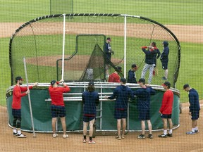 Members of the Regina Red Sox set up equipment before a practice at Currie Field, where the Western Canadian Baseball League team is to hold its home opener Tuesday
