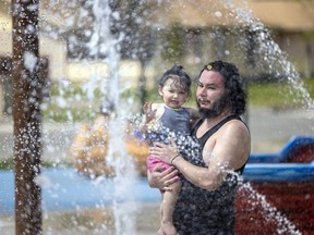 Conrad Peekeekoot and his 1-year-old daughter Sybil Peekeekoot enjoy the opening day of the spray pad located at the North West Leisure Centre on Tuesday, May 24, 2022 in Regina.