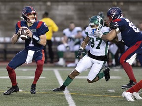 Montreal Alouettes quarterback Trevor Harris (7), left, prepares to throw the ball as Montreal Alouettes tackle Nick Callender (62) clears Saskatchewan Roughriders defensive lineman Keion Adams (97) during CFL action in Montreal on Thursday, June 23, 2022.