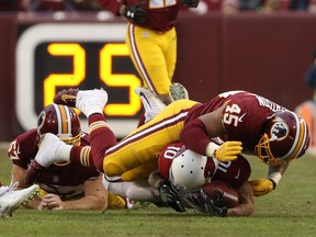 Pete Robertson, 45, of the Washington Redskins (now Commanders) tackles Brittan Golden of the Arizona Cardinals during an NFL game on Dec. 17, 2017.