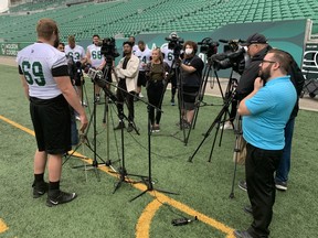 Logan Bandy is interviewed at Mosaic Stadium on Tuesday while several of his fellow Saskatchewan Roughriders offensive linemen listen in.