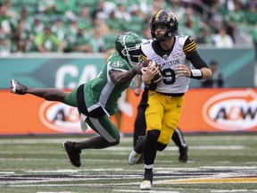 A.C. Leonard, left, was part of a Saskatchewan Roughriders defensive line that exerted constant pressure on Hamilton Tiger-Cats quarterback Dane Evans, right, on Sunday at Mosaic Stadium.