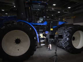 Crews wipe down farm equipment before the Canada’s Farm Show inside the REAL District earlier this week.