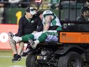 Saskatchewan Roughriders centre Dan Clark is shown with assistant athletic therapist Trevor Len after suffering an ankle injury late in Saturday's game against the host Edmonton Elks.