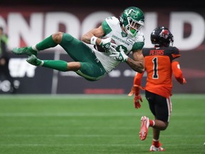 Saskatchewan Roughriders' Kian Schaffer-Baker, front left, makes an acrobatic reception during the first half of Friday's pre-season game at BC Place against the B.C. Lions.