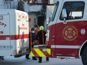 A Regina Fire Department investigation team works on the site of a house fire on the 400 block of Royal Street in Regina, Saskatchewan on Feb. 18, 2021.