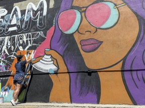 Artist Carly Jaye Smith paints a new mural on the side of Leopold's Tavern downtown, as part of a new street art project from Audacity yQR.