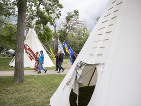 Flag carriers of the Grand Entry walk into the National Indigenous Peoples Day celebrations in Regina. The event returned in person for the first time in two years.