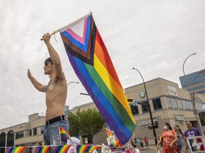 A parade goer sits on the back of a Camp Fyrefly float thats riding down Albert street during Queen City Pride Parade on Saturday, June 11, 2022 in Regina.