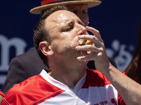 Joey Chestnut eats as he competes for his 15th championship title during the 2022 Nathan's Famous Fourth of July hot dog eating contest on Coney Island on July 4, 2022 in New York. - Joey Chestnut won by eating 63 hot dogs and buns.