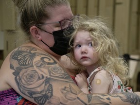Isabella Stewart, 2, waits with her mom Megan after getting a COVID-19 vaccination shot at a clinic in the Victoria Square Mall in Regina on Friday July 22, 2022. It's the first day that children six-months to five-years-old can get a COVID-19 vaccination.