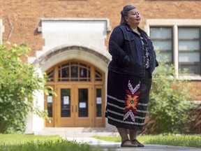 Vanea Cyr, supervisor of Indigenous education for Regina Public Schools, stands in front of The Crescents School main entrance. A stone, formerly above the door and carrying the name Davin School, was removed this week.