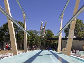 Hot summer weather made Maple Leaf pool a popular place on Tuesday, July 12, 2022 in Regina.  10-year-old Jarrett Hrushowy jumps off the diving board.