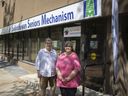 Holly Schick, kanan, dan Linda Anderson berdiri di depan potret di luar kantor Mekanisme Lansia Saskatchewan pada bulan Juni.