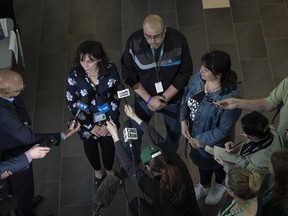Translator Iryna Kavetska (L) stands beside Ukrainian temporary residents Ihor Osoba and Nataliia Osoba speak to the press during an event to meet with service providers (health cards, SIN numbers, drivers license, SIM cards, housing, school, employment opportunities) at the University of Regina on Thursday, July 7, 2022 in Regina.