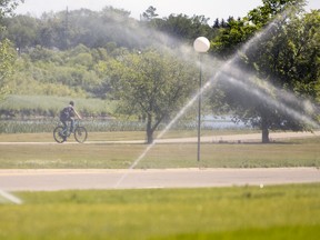 A bicyclist rides through Wascana Center on Tuesday, July 12, 2022 in Regina as temperatures edged close to 30C.