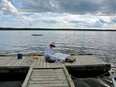 Catherine Perehudoff Fowler painting on the dock at the Emma Lake Artists' Workshop in 2011.