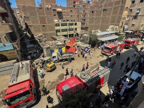 Civil protection personnel work at the scene after a fire tore through a Coptic Christian church on August 14, 2022 in the Imbaba neighborhood of Giza, Egypt. More than 40 people were killed in the fire, which took place during Sunday mass.