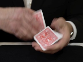 Doug Arden, ventriloquist and professional magician, shuffles a deck of cards at home.  Close-up card magic is part of his act.