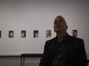 Guest curator Gary Varro sits in front of photographs by Linda Simpson during the opening reception for The Drag Explosion at the Art Gallery of Regina on Thursday, August 11, 2022 in Regina.