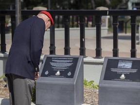 An attendee inspects the two new pedestals during an event that unveiled the plaques to commemorate Canadian war efforts, by the South Saskatchewan Regiment, which fought in the Dieppe Raid on Aug. 19, 80 years ago. The event was held at Cenotaph at Victoria Park on Friday, August 19, 2022 in Regina.