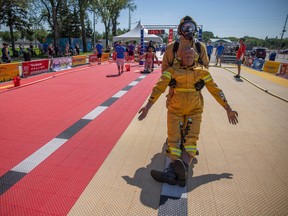 Seth Barker from the Regina Fire Department carries a weighted dummy as he competes during the FireFit Championship Regionals at Brandt Centre parking lot on Saturday, Aug. 27, 2022 in Regina.