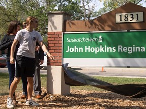 Cody Hopkins, son of the late John Hopkins unveils a sign during a formal event where the Government of Saskatchewan and family of the late John Hopkins unveiled new signage to mark the John Hopkins Regina Soundstage's new name.