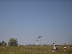Les participants traversent un champ en direction du pow-wow annuel de la Ranch Ehrlo Society sur leur campus de Pilot Butte le jeudi 25 août 2022 près de Pilot Butte.