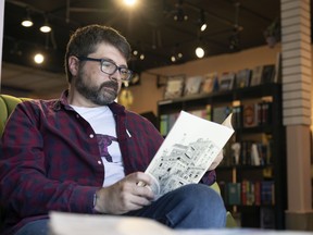 Anthony Woodward,  a local comic book artist, founder and publisher at Spare Parts Press, flips through a copy of his own title, Woodlands No. 1, currently stocked at Penny University Bookstore.