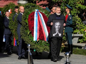 Nobel Peace Prize awarded journalist Dmitry Muratov carries a portrait of former Soviet Union President Mikhail Gorbachev during his funeral at Novodevichy Cemetery in Moscow, Sept. 3, 2022.