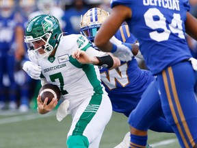 Saskatchewan Roughriders quarterback Cody Fajardo (7) gets tackled by Winnipeg Blue Bombers? Willie Jefferson (5) during the first half of CFL football action in Winnipeg on Saturday.