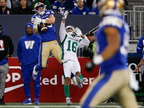 Winnipeg Blue Bombers’ Dalton Schoen catches a pass over the Saskatchewan Roughriders’ Amari Henderson on Friday. Schoen ended up scoring a 64-yard touchdown.