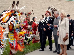 This file photo shows Britain’s then-Prince Charles (now the King) and and his wife Camilla, the Duchess of Cornwall with Chief Mike Star of the Starblanket First Nation (L) watching dancers at First Nations University of Canada in Regina on May 23, 2012. Hip-hop artist Brad Bellegarde was among those who performed in front of Charles during the visit.
