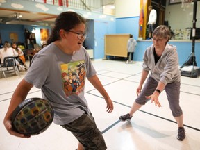 Sandra Pfeifer, right, youth CARE programmer supervisor, shots some hoops with 11-year-old Alex Bear at the Rainbow Youth Centre on Friday, September 9, 2022 in Regina.