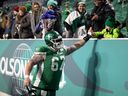 Veteran centre Dan Clark, shown high-fiving fans at Mosaic Stadium last season, is expected to return to the Saskatchewan Roughriders' lineup Friday against the host Winnipeg Blue Bombers.