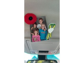 A ribbon that was gifted to Humboldt Broncos mom Celeste Leray-Leitch by Lissa Bear, an Indigenous artist and member of James Smith Cree Nation, is seen beside a family photo in an undated handout image. The Humboldt Broncos mom carries the pin with her on her vehicle's visor alongside a poppy and a photo of her four children when they were young.
