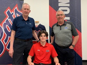Cole Temple, centre, is shown signing a standard WHL player agreement with the Regina Pats shortly after being selected fifth overall in the 2022 prospects draft. Also shown are head coach and general manager John Paddock, left, and director of scouting Dale McMullin.
