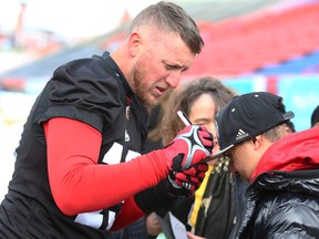 Columnist Rob Vanstone feels that the Saskatchewan Roughriders should go all out to sign quarterback Bo Levi Mitchell, who is shown earlier this week accommodating an autography request from a young Calgary Stampeders fan.