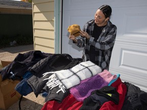 Comeback Society CEO Alicia Morrow holds donated garments for this year's winter clothing drive, which began Sunday at partnered pick-up and drop-off location The Everyday Kitchen.