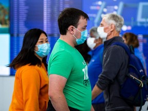 Travellers wear masks at Toronto's Pearson airport on Sept 26.