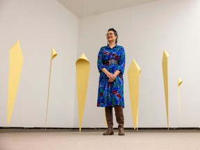 Curatorial fellow Felicia Gay, who has put together a retrospective exhibition on the career of contemporary artist Faye HeavyShield, stands by one of the installations at the MacKenzie Art Gallery on Thursday, October 20, 2022 in Regina.