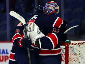 Regina Pats forward Easton Armstrong, left, hugs goalie Drew Sim after Wednesday's 3-0 victory over the visiting Prince Albert Raiders.