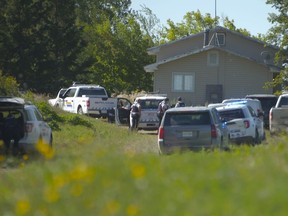 In this image taken from video, Canadian law enforcement personnel surrounded a residence on the James Smith Cree First Nation reservation in Saskatchewan on Tuesday, Sept. 6, 2022, as they search for a suspect in a series of stabbings. The federal government is to spend $1.2 million to repair and replace houses damaged during the stabbings.