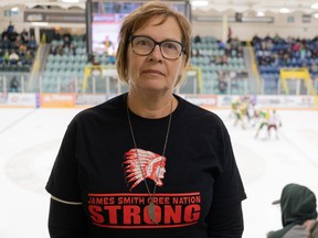Carol Brons, wearing a James Smith Strong t-shirt, stands in front of a Humboldt Broncos game in the Elgar Petersen Arena in Humboldt, Sask on Nov. 20, 2022.