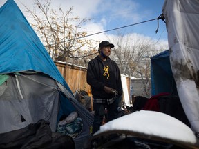 Randy Netmaker stands for a portrait  next to a makeshift camp on Halifax street for those experiencing homelessness on Tuesday, October 25, 2022 in Regina.