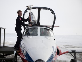 The Grey Cup is carried off the Snowbirds Blue Hangar tarmac by Snowbirds Crew Chief Vincent Brouillette after being delivered by a Royal Canadian Air Force aircraft on Monday, November 14, 2022 in Moose Jaw.