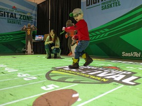 Megan Welder and her four-year-old son, Elliot, play Field Goal Frenzy as part of the Grey Cup Festival activities at the International Trade Centre.