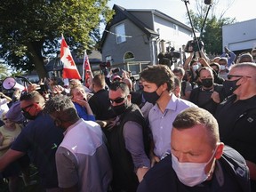 Liberal Leader Justin Trudeau is escorted by his RCMP security detail as protesters shout and throw rocks while leaving a campaign stop at a local micro brewery during the federal election campaign in London Ont., Sept. 6, 2021.
