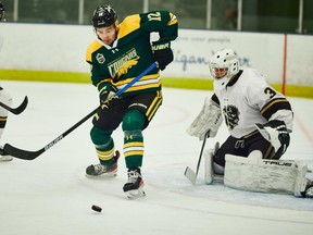 Eric Houk (12) of the University of Regina Cougars battles for the puck during a recent Canada West men's hockey game against the Manitoba Bisons.  Photo by Arthur Ward/Arthur Images