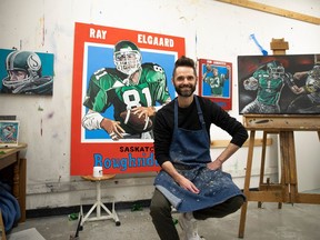 Luther College High School art teacher Drew Hunter sits for a portrait with his Roughriders-related art work inside the classroom he teaches in on Wednesday. KAYLE NEIS / Regina Leader-Post